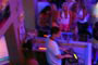 DJ tocando na Balada de Cambori&uacute; e  ao fundo a galera dan&ccedil;ando muito.