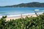 Mo&ccedil;a correndo na Praia de Mariscal em Bombinhas e ao fundo um cen&aacute;rio maravilhoso de preserva&ccedil;&atilde;o a mata nativa.
