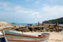 Barco de pesca e pessoas ao fundo se divertindo na Praia da Lagoinha em Bombinhas.