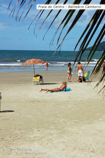 Garota tomando sol na praia central de Balneário Camboriú.