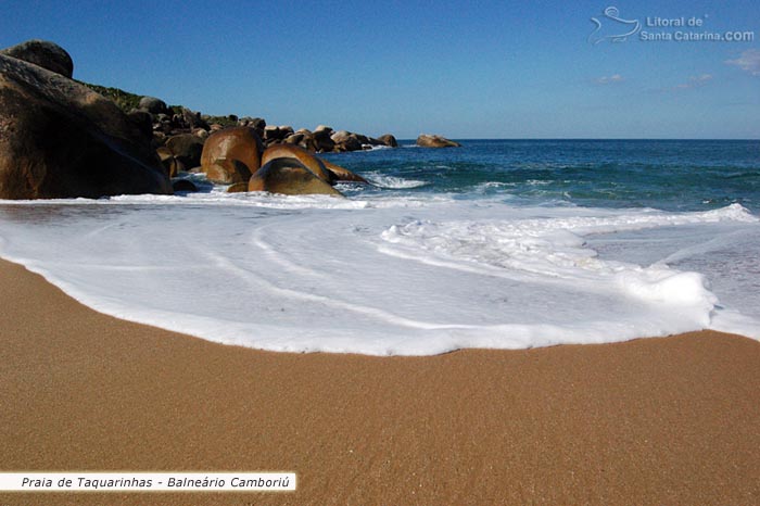 Espuma do mar passando sobre as areias límpidas da praia de taquarinhas em Balneário Camboriú.