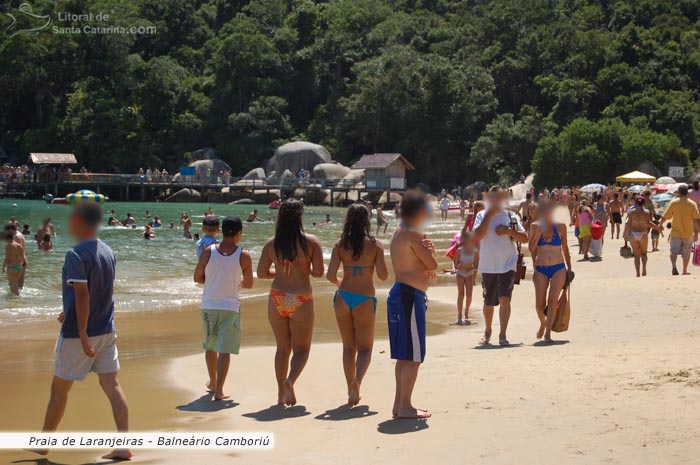 Tur�stas caminhando pela praia de laranjeiras em Balne�rio Cambori�.