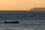Nascer do sol na praia de 4 ilhas, barco saindo para a pesca e no fundo a Ilha do Arvoredo.