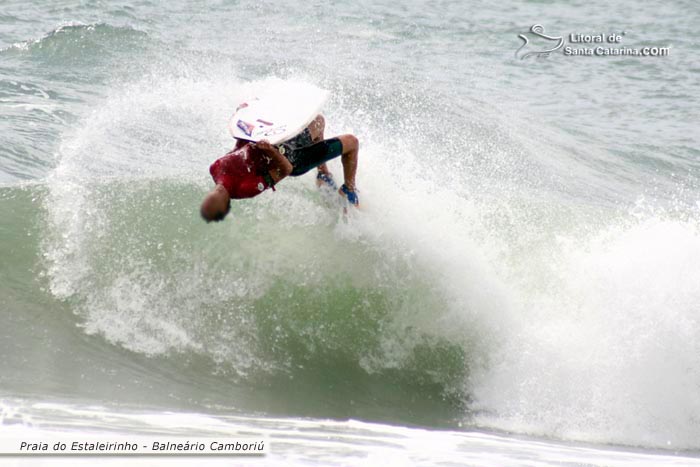 Rapaz surfando na praia do estaleirinho em Balneário Camboriú.