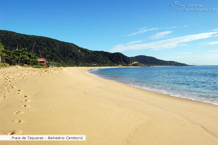 Areia limpa e mar parecendo uma piscina na praia de taquaras em Balneário Camboriú.