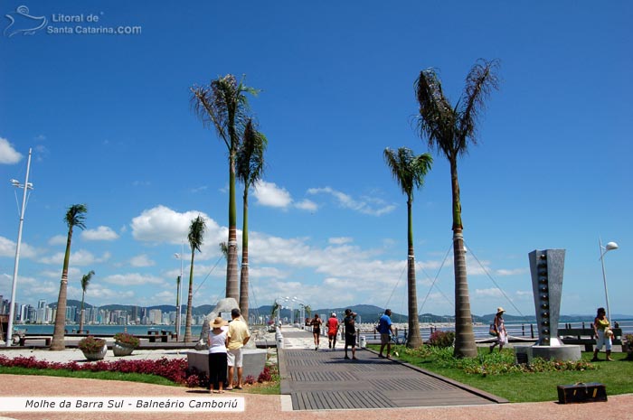 Pessoas passeando pelo molhe da barra sul em Balneário Camboriú de dia.