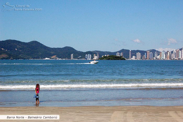 Criança se divertindo na barra norte de Balneário Camboriú e ao fundo a ilha das cabras.