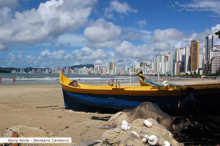 Barco parado na barra norte de balneário camboriú e ao fundo o mar lisinho. 