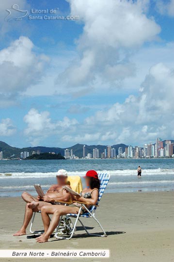 Casal relaxando na barra norte em balneário camboriú e aproveitando este momento especial para ler um bom livro.