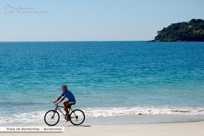 Rapaz passeando tranquilamente pelas areias branquinhas da Praia de Bombinhas.