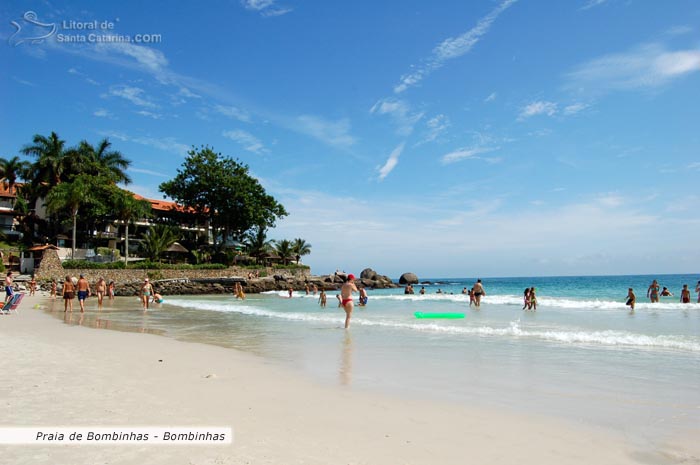 Famílias se divertindo na Praia de Bombinhas e ao fundo o marivilhoso Hotel Bombinhas Tourist.