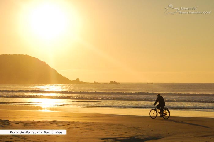 Sol nascendo em Mariscal e o Sr. passeando calmamente com sua bicicleta.