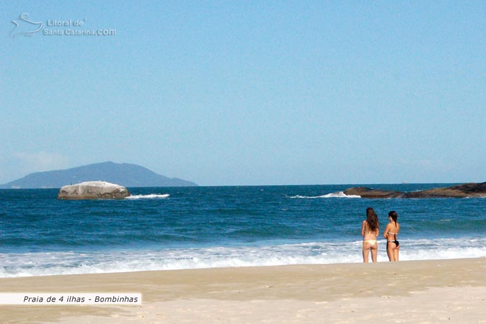 Duas garotas adimirando o cenário maravilhoso da Praia de Mariscal em Bombinhas.