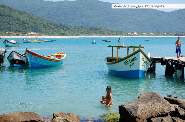 criança caminhando sobre as águas límpidas da praia da armação