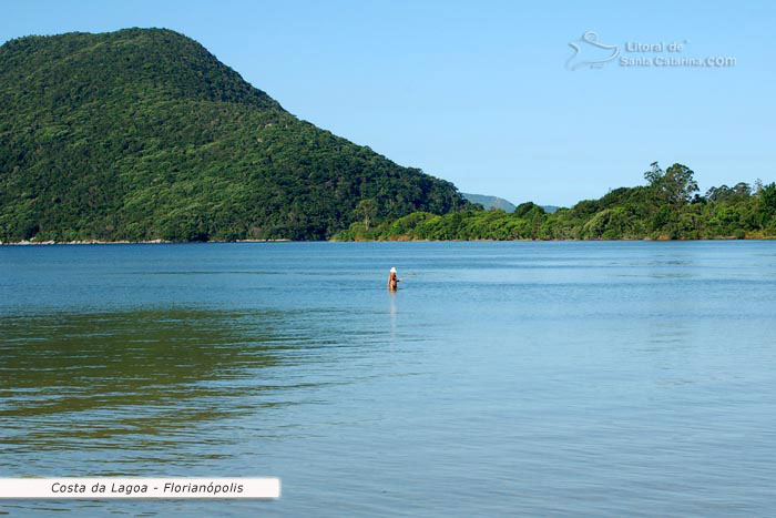 uma senhora sozinha dentro das águas da costa da lagoa