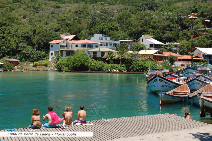 Pessoas sentada no deck e adimirando as belzas do canal da barra da lagoa em florianopolis - sc.