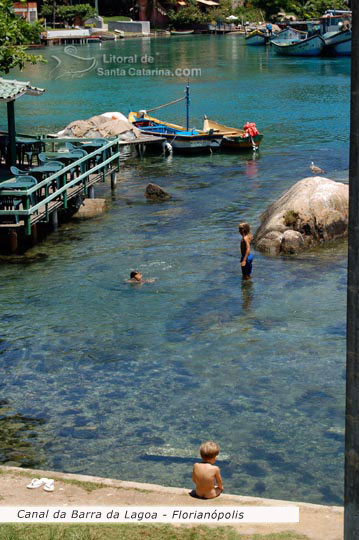 Barra da lagoa, crianças nadando e a mãe cuidando e outro garoto só adimirando a paisagem e os peixinhos no mar