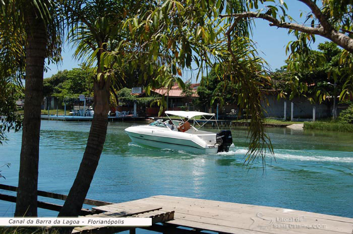 Lancha indo ao encontro do mar, saindo do canal da barra da lagoa