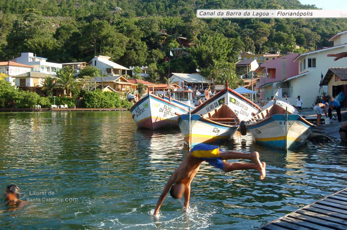 Garotos saltando do deck para o canal da barra da lagoa em santa catarina