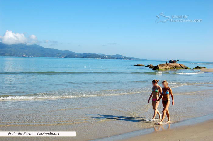 mulerada caminhando calmamente pela praia do forte em floripa sc