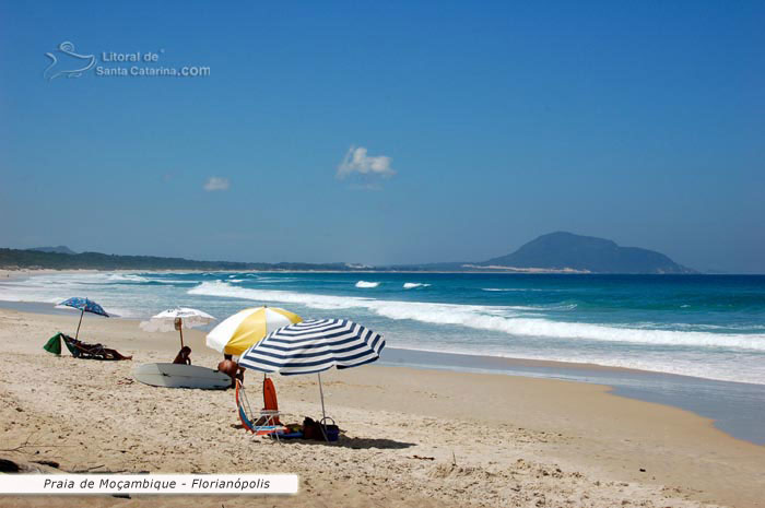 moçambique, galera em baixo do guarda sol, e um mar super azul e ótimo pico para a prática de surf