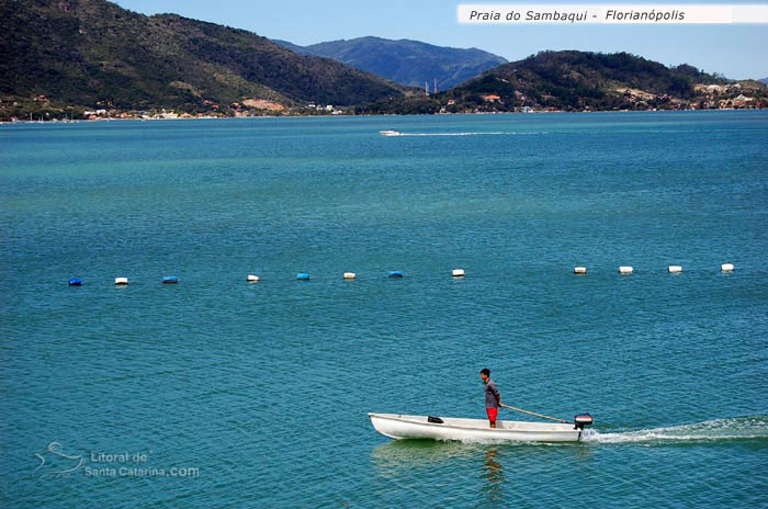 pescador de barco aqrrumando a rede de pesca na praia do sambaqui