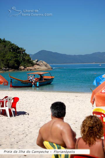 Ilha do campeche, pessoas sentadas relaxando com as belezas das praia de santa catarina