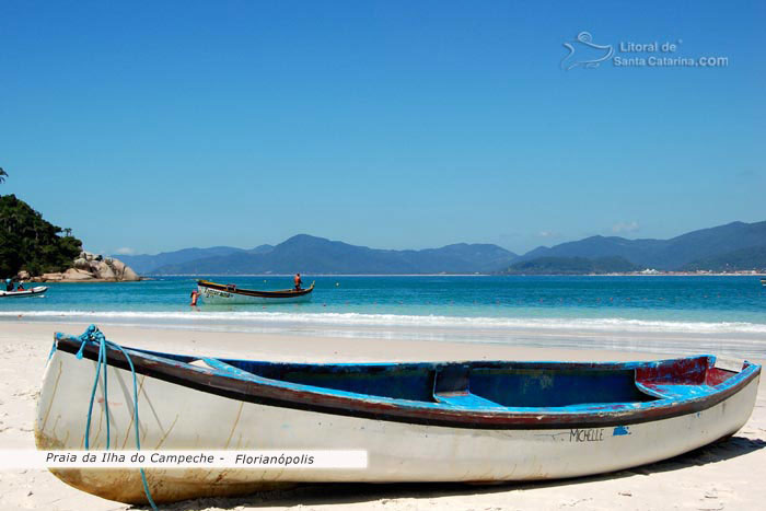 Barco na ilha do campeche e ao fundo um pescador saindo de barco a procura de peixes