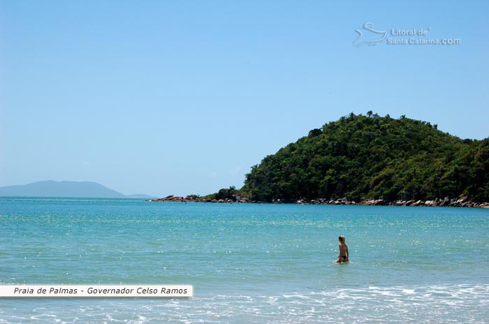Praia de Palmas em Governador Celso Ramos, garota entrando no mar transparente desta linda praia do litoral sc 