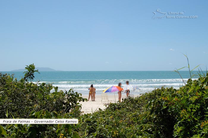 Praia de Palmas, restinga, pessoas batendo um papo na praia e  ao fundo um mar paradisíaco