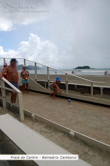 Senhoras e Senhores jogando bocha na praia central de Balneário Camboriú e ao fundo a ilha das cabras.