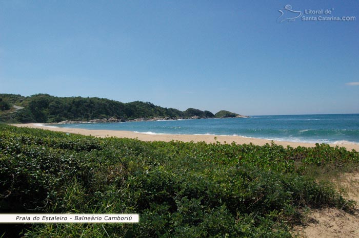 Restinga preservada e mar azul da praia do estaleiro em Balneário Camboriú.
