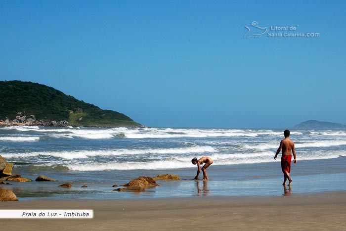 Turistas passeando nas areias da praia do luz