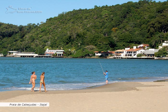 gatas fazendo caminhada na praia de cabeçudas, homem pescando e muito sol