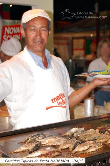 homem servindo sardinhas na festa marejada itajaí