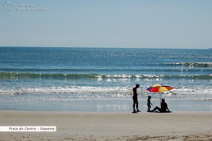 Família aproveitando um lindo dia de sol na praia de itapema.