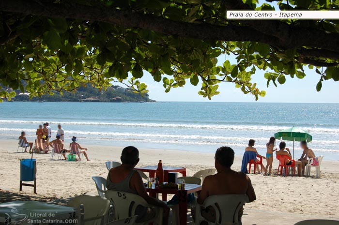 Pessoas tomando um cervejinha na beira da praia de itapema.