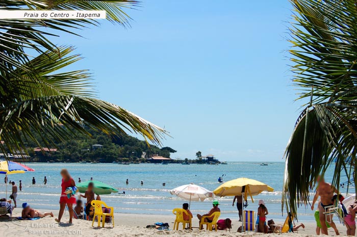 Praia de Itapema, pessoas aproveitando nas areias e outras passeando de caiaque.