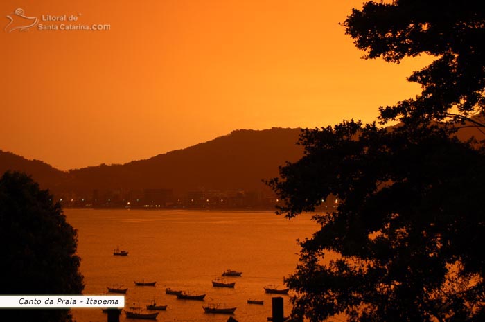 Céu alaranjado do final de tarde no canto da praia em itapema.