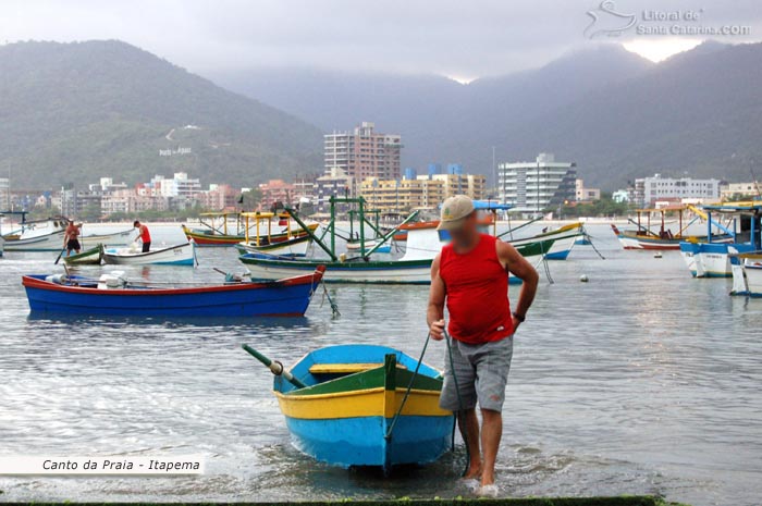 Pescador puxando o barco na orla do canto da praia em itapema.