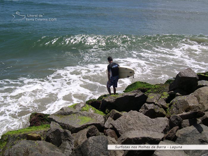 surfistas saindo dos molhes, para fazer um surf em laguna