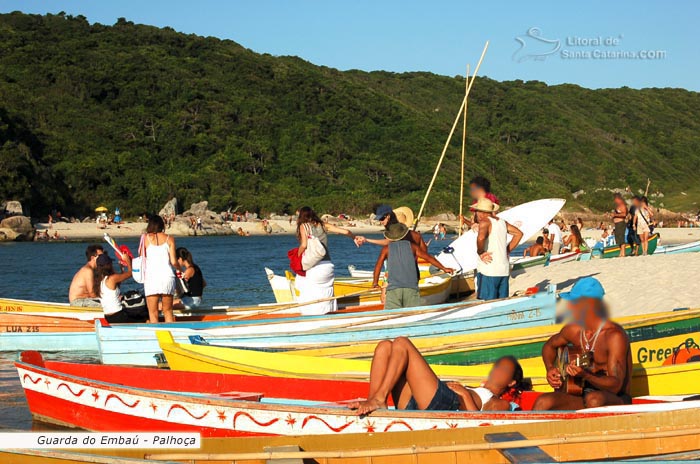 Guarda do embau, homem tocando um violão no barco e sua mulher relaxando.