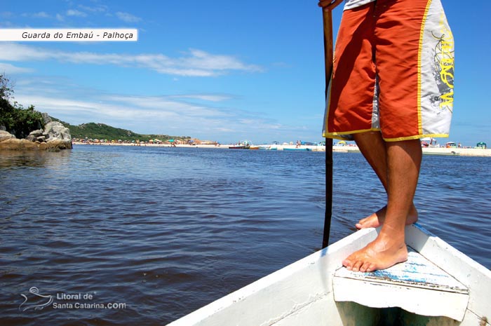 pescador atravessando os turistas de barco na guarda do embaú