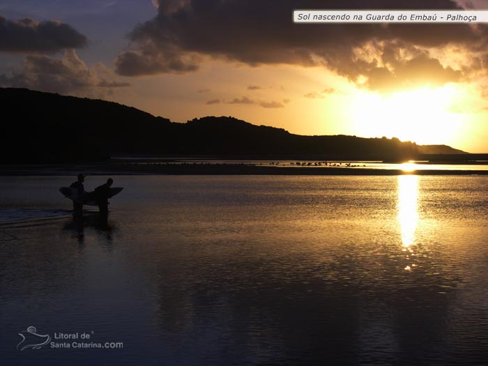 sol nascendo na guarda do embau em santa catarina e a galera já indo fazer um surf em altas ondas que rolam nesta linda praia catarinense