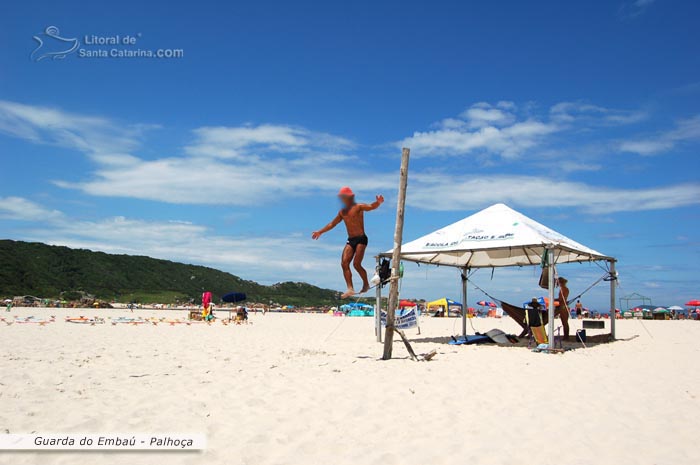 homem fazendo malabarismo na praia da guarda do embau