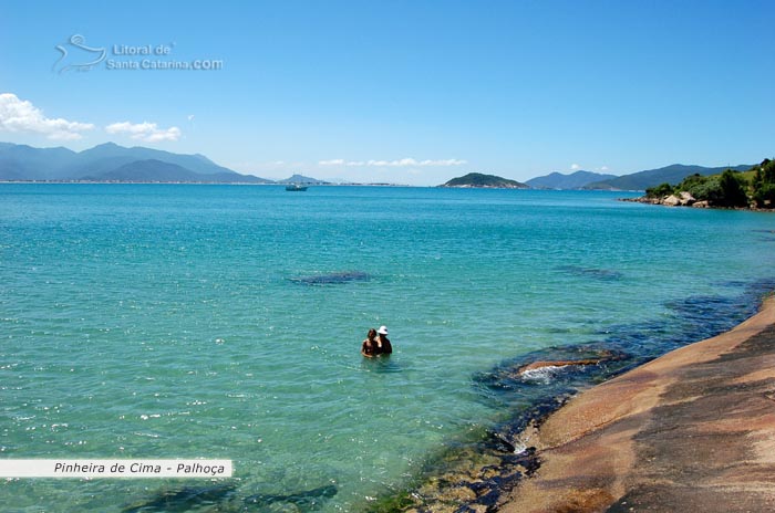 duas mulheres dentro das águas da praia pinheira, adimirando a limpeza das águas de santa catarina