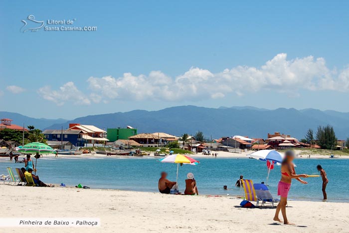 praia da pinheira, pessoas tomando sol e outras jogando frescobol