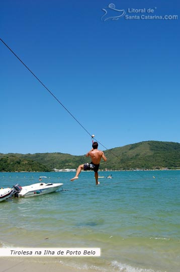 Ilha de porto belo em Santa Catarina, rapaz descendo de tiroleza nas águas cristalinas da ilha.