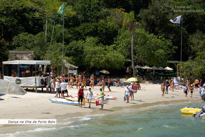 Ilha de porto belo, pessoas passeando e outras dançando na areias da ilha.