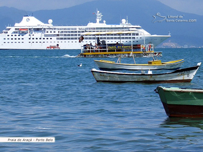 barcos parados na praia do araca e ao fundo um transatlantico